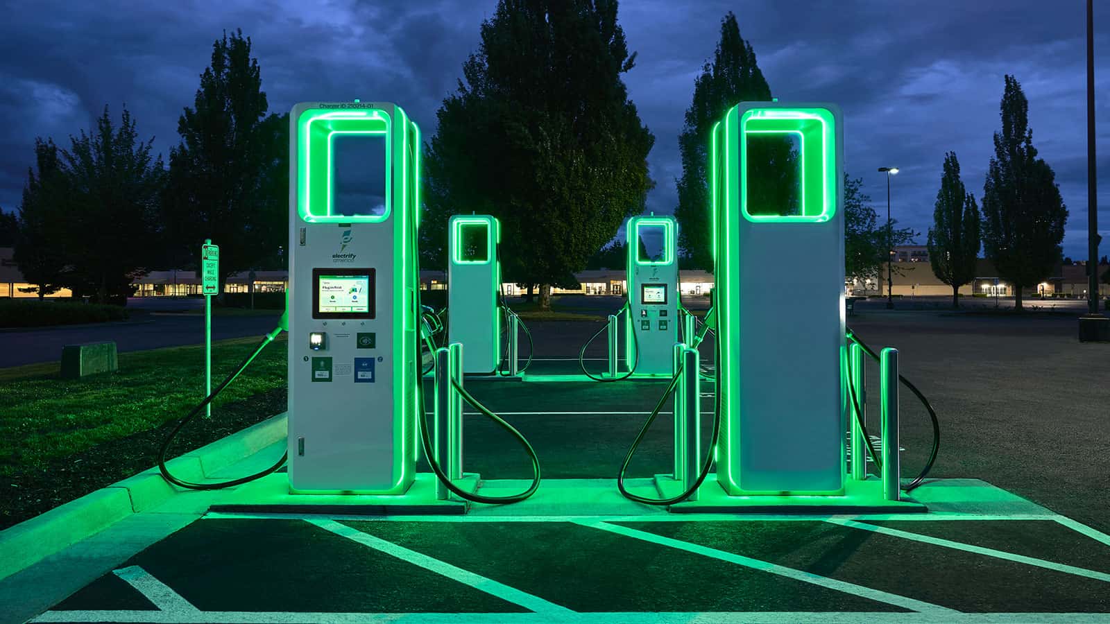 Modern electric vehicle charging station at night with neon green lights