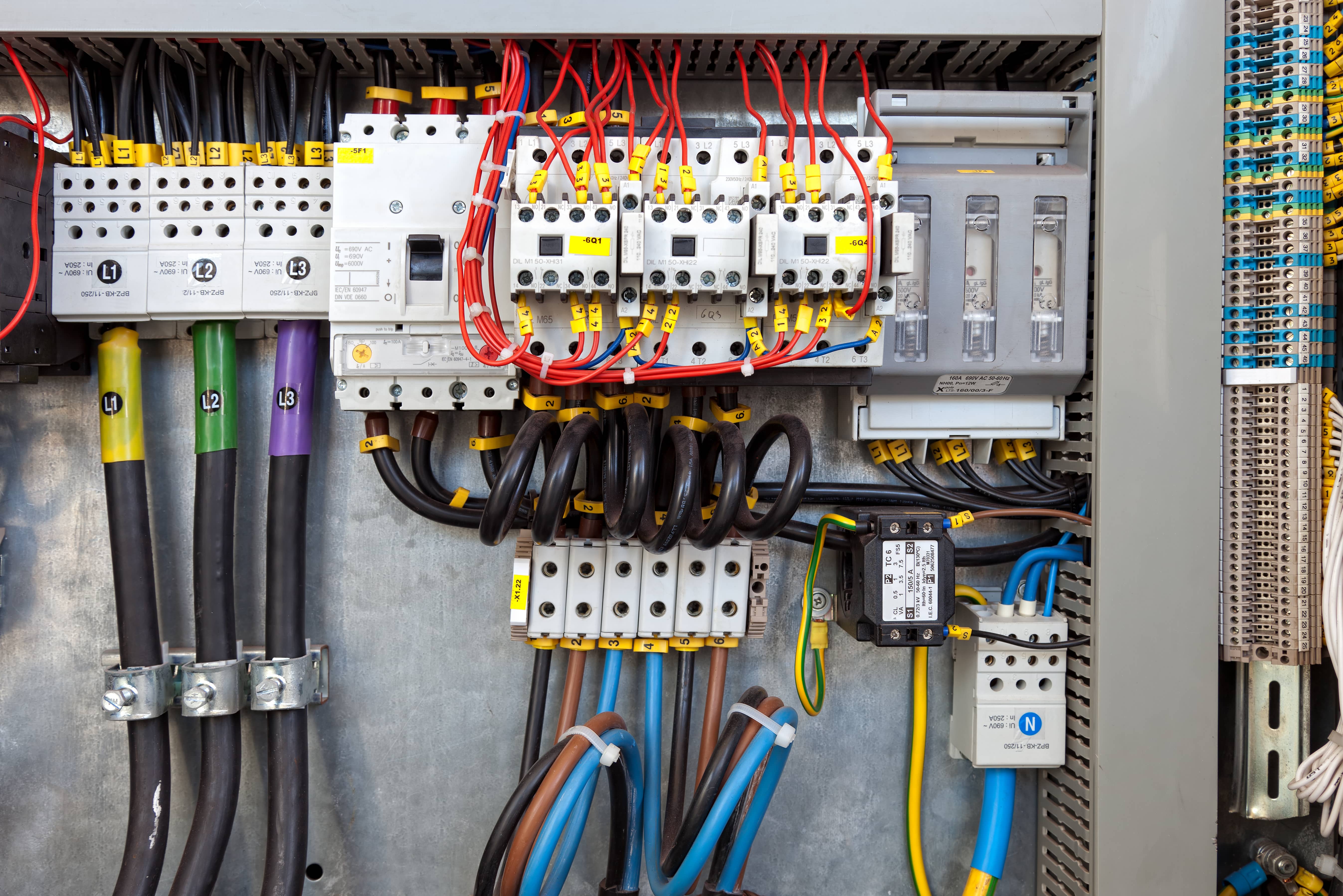 Industrial electrical distribution panel with color-coded wiring and circuit breakers